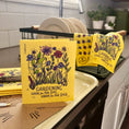 Load image into Gallery viewer, Bright yellow reusable swedish sponge cloth with floral design and gardening good for the soil great for the soul text
