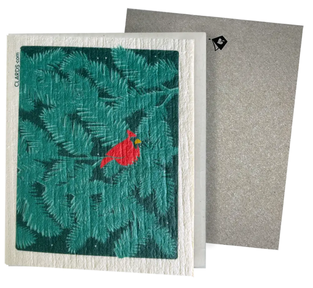 A red cardinal on teal pine branches on a white embossed eco greeting card turns into reusable swedish sponge cloths