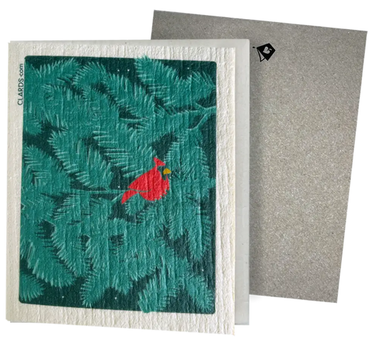 A red cardinal on teal pine branches on a white embossed eco greeting card turns into reusable swedish sponge cloths