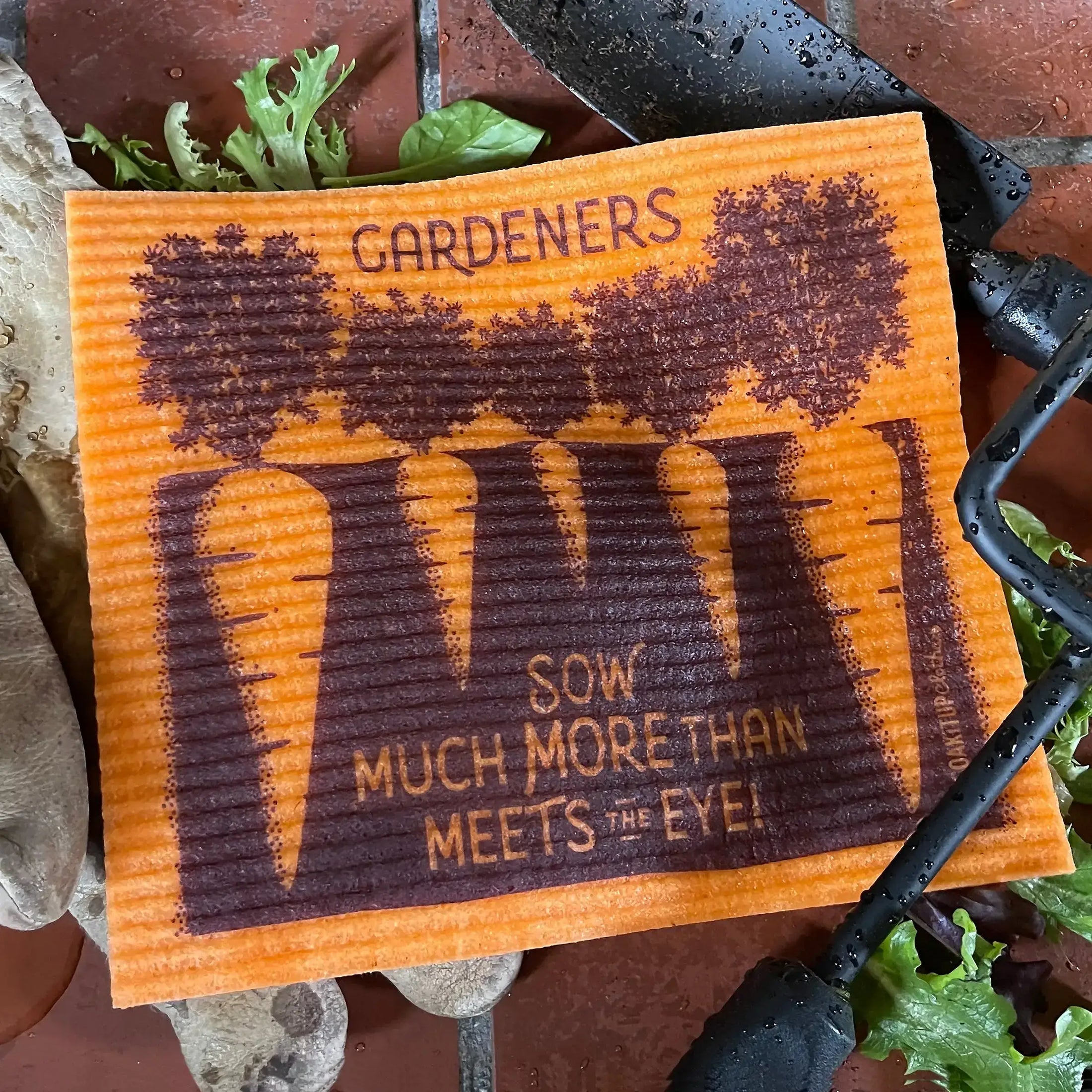 Orange wet Swedish dishcloth with carrots and "gardeners sow much more  than meets the eye" message
